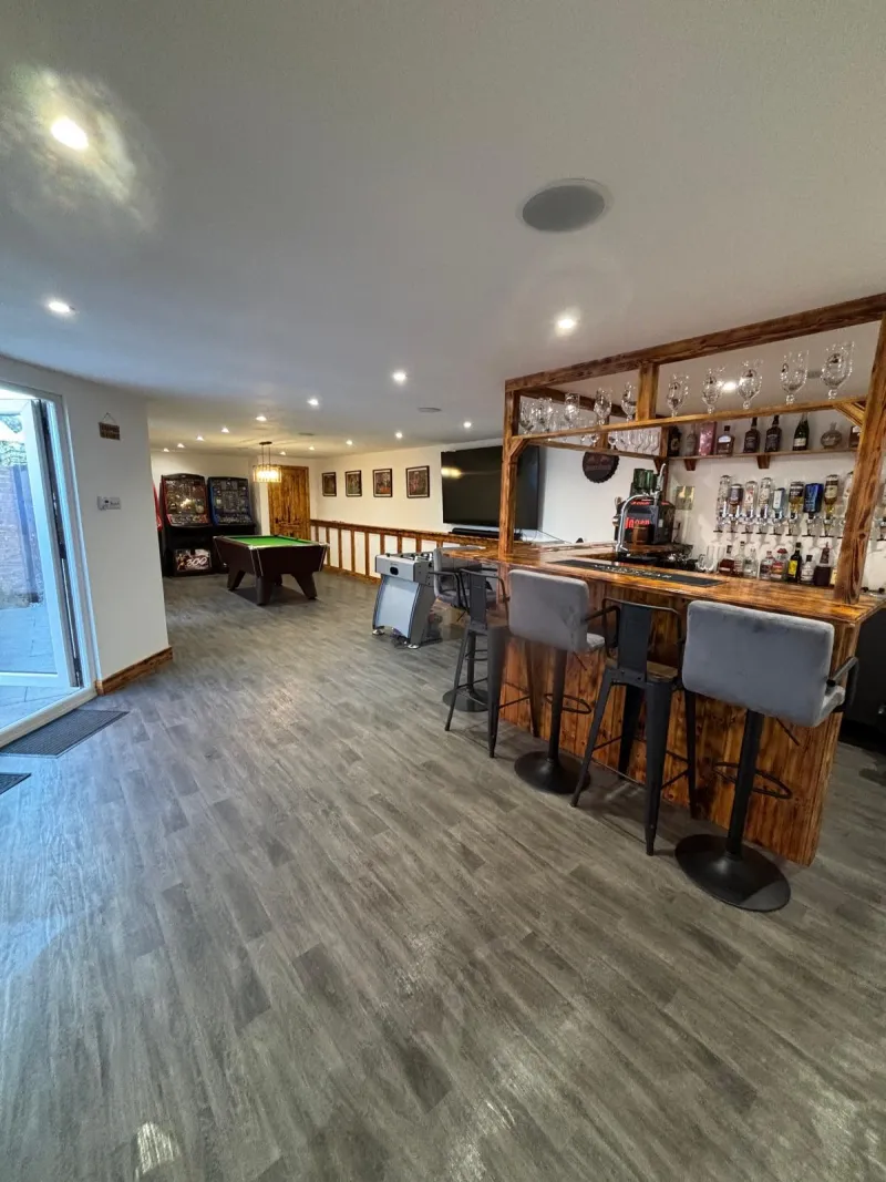 Converted basement games room with bespoke timber bar, pool table and LVT flooring by AG Joinery Blackburn