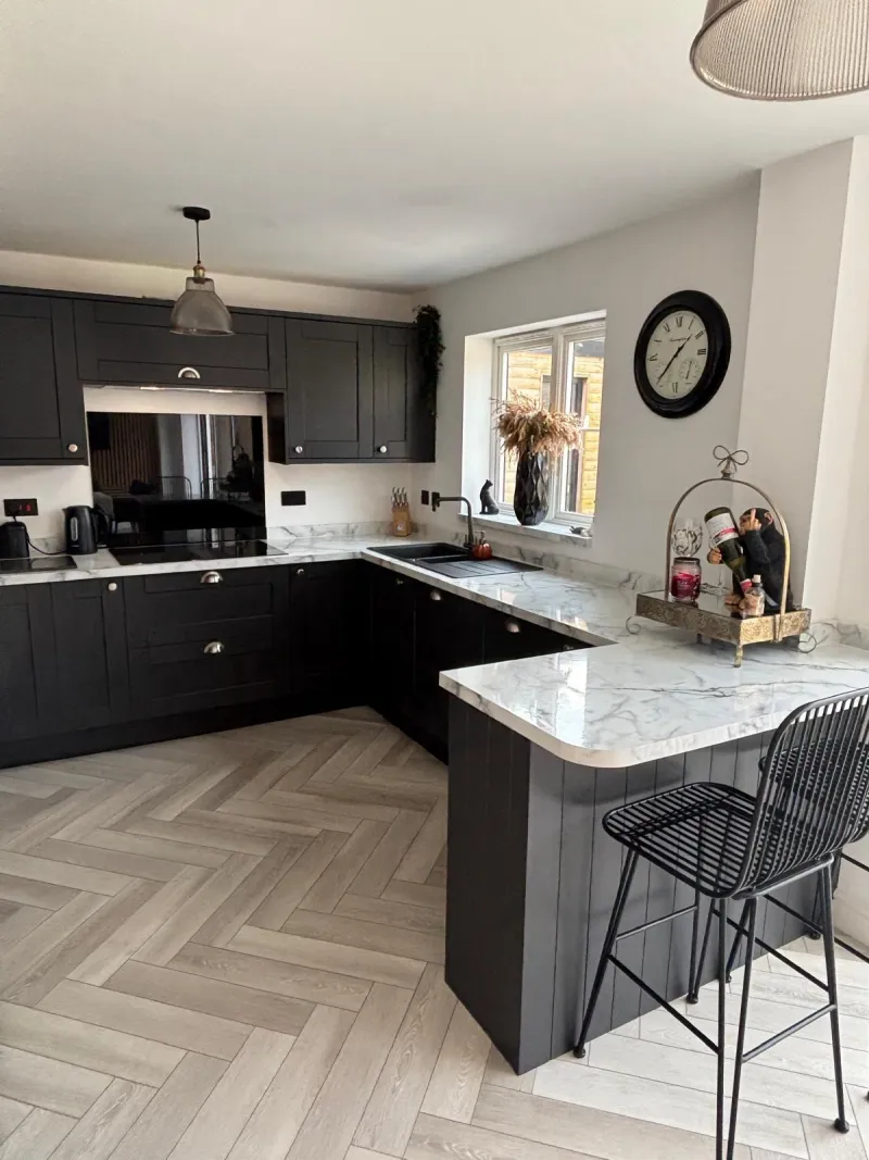 Matte black shaker kitchen with marble worktops and herringbone floor by AG Joinery Lancashire