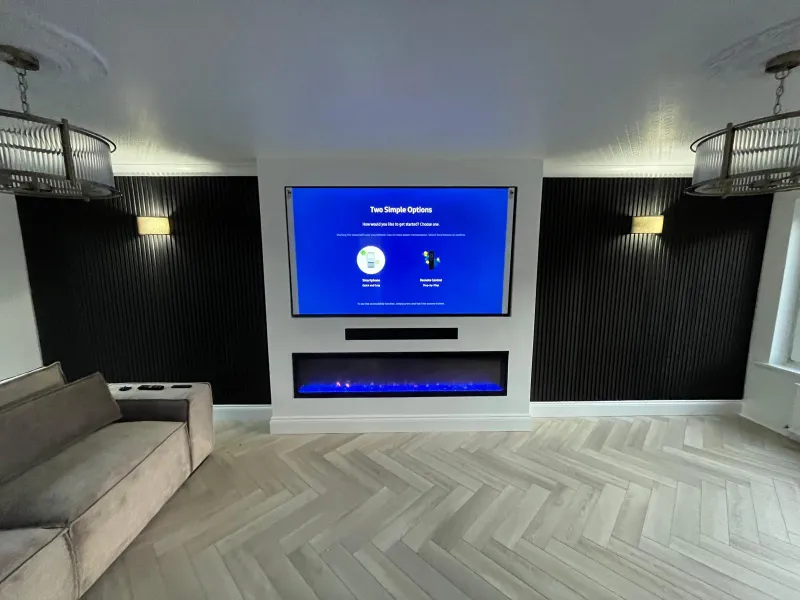 Media wall with black fluted panels, electric fire and herringbone floor by AG Joinery Blackburn