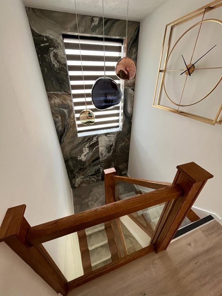 Feature staircase with marble wall tiles and glass balustrade by AG Joinery